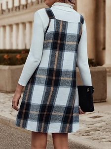 Nahaufnahme des Vintage-Karo-Trägerkleids und der weißen Rollkragen-Stricktextur