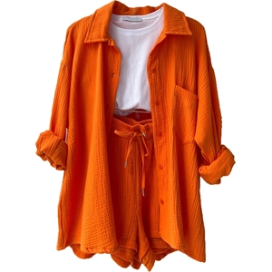 Detailed view of women's orange crinkle fabric shirt and matching drawstring shorts set