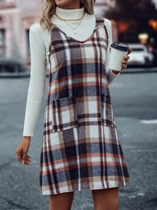 Detail von Vintage-Trägerkleid mit Karomuster, Taschen und weißem Rippstrickpullover