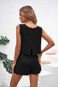 Detail view of the black two-piece set featuring back buttons and slit on the sleeveless top