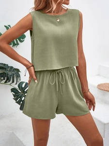 Detailed texture of sage green linen fabric on sleeveless top and drawstring shorts