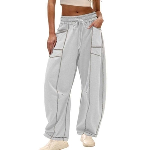 Detail of light grey wide-leg joggers with elastic drawstring waist and large cargo pockets