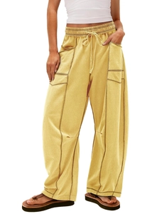 Detail of high-waist mustard yellow cargo pants with drawstring and contrast stitching