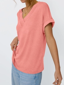 Detail of coral orange V-neck t-shirt featuring rolled sleeves and textured fabric
