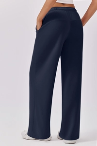 Back view of high waisted navy blue wide leg sports trousers with elastic waist