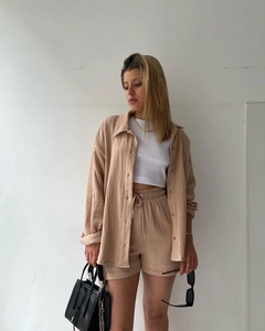 Detail of beige textured cotton two-piece set featuring a long sleeve shirt and drawstring shorts