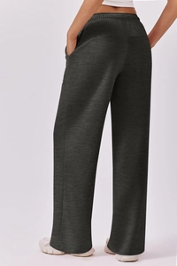 Detail view of high-waist elastic waistband and side pocket on dark grey wide-leg joggers