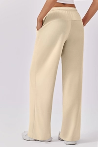 Detail view of the high-waist elastic waistband and back seam on beige wide-leg pants