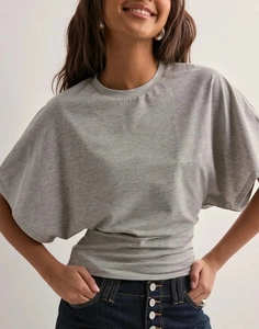 Detail of grey batwing sleeve top with ruched waist and textured knit fabric