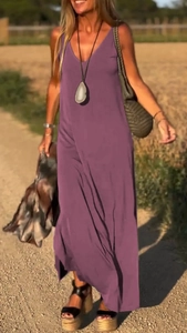 Dettaglio dell'abito lungo viola con scollo a V e drappeggio elegante con luce calda