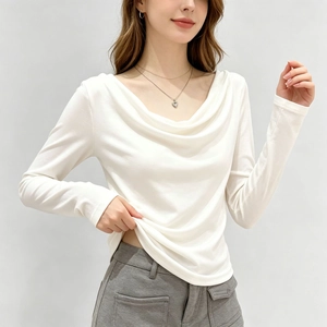 Détail d'un haut blanc élégant à col bénitier et manches longues avec une coupe ajustée