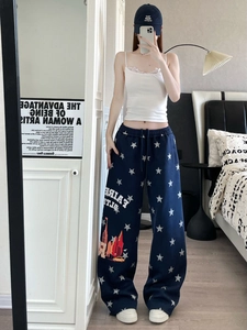Dettaglio dei pantaloni sportivi blu scuro a gamba larga con stampa a stelle e coulisse