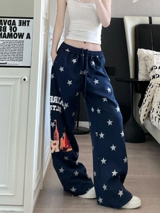 Dettaglio dei pantaloni joggers blu navy con motivi a stelle e stampa urbana