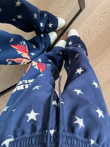 Dettaglio dei joggers blu navy con stelle bianche e grafica dello skyline urbano