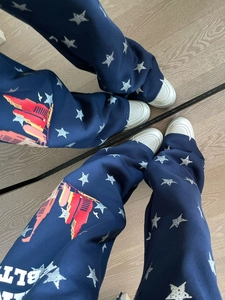 Dettaglio dei joggers blu navy con stelle argentate e stampa grafica cittadina