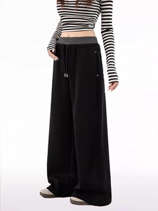 Detail of high-waisted wide leg sweatpants with grey elastic waistband and black drawstring