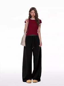 Detailed view of women's black wide-leg joggers with drawstring and wine red t-shirt