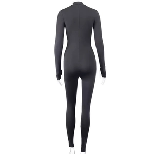 Detailed back view of sleek black slim fit yoga jumpsuit with center seam on mannequin