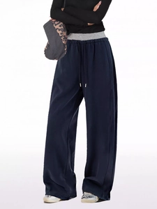 Detail of dark blue wide-leg joggers with gray contrast drawstring waistband and soft texture