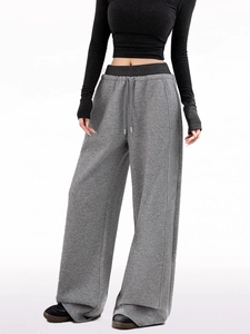 Detail view of the gray wide-leg sweatpants featuring a drawstring high waist and knit fabric