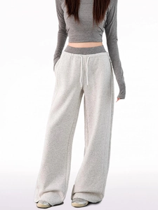 Detail of light gray wide-leg joggers with contrasting white drawstring and soft fabric