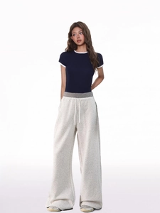 Detail of light gray wide-leg sweatpants with white drawstring and elastic waistband