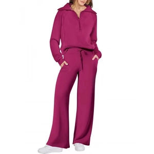 Dettaglio della tuta sportiva rosa bacca con felpa a mezza zip e pantaloni larghi