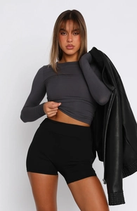 Detail of slim fit dark gray long sleeve top paired with a black faux leather moto jacket