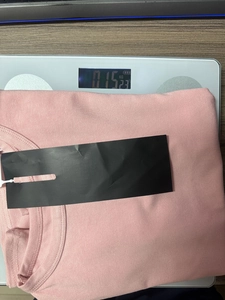 Pink slim fit sports T-shirt weighing 0.15kg displayed on a white digital scale