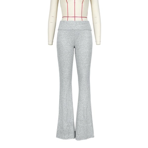Detail of light grey flare pants with high-waisted fold-over waistband and knit texture