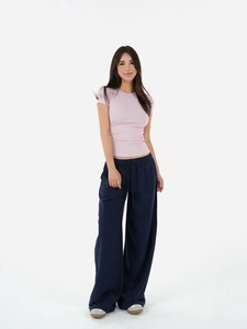 Close-up of a pale pink slim fit crew neck T-shirt with navy drawstring wide leg trousers
