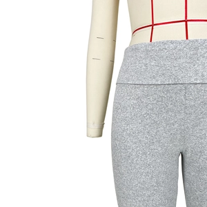 Detail view of heather grey high-waisted yoga pants with wide elastic waistband