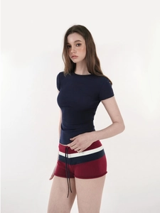 Detail view of a slim fit navy T-shirt paired with retro striped knit shorts with drawstrings
