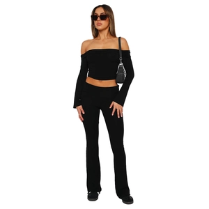 Detail of slim-fit black off-shoulder crop top and high-waisted flared trousers set