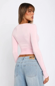 Close-up of pink slim-fit crop top texture and high-waisted denim jeans back detail