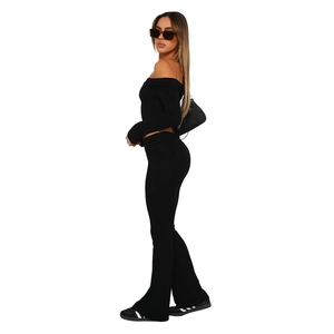 Detail view of black off-shoulder crop top and matching slim-fit flared trousers