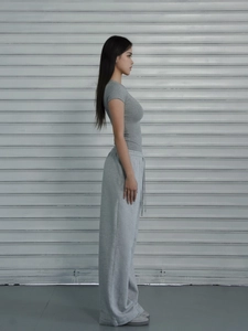 Detail of grey slim-fit athletic t-shirt and high-waist wide-leg pants on model