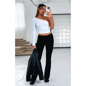 Detail view of women's black low-waist flare pants styled with a one-shoulder top