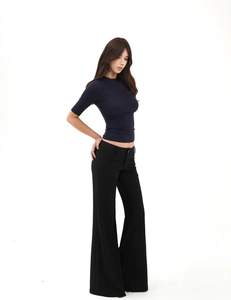Detail of slim-fit navy short-sleeve top and high-waist black flared trousers on model