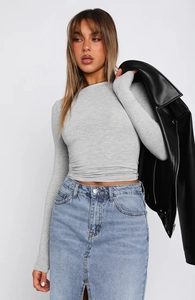 Detail of grey slim-fit long sleeve top with blue denim skirt and black leather jacket