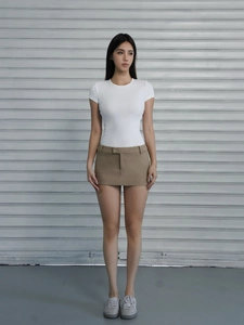 Front view of slim fit white short sleeve T-shirt paired with a khaki mini skirt