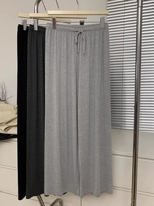 Détail de la taille élastique et des cordons de serrage sur des pantalons larges en trois coloris