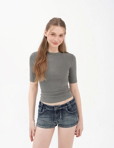 Close-up of slim fit grey crew neck T-shirt paired with washed denim shorts