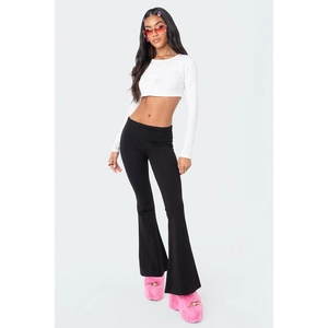 Detail of white long sleeve crop top and black flared trousers set on model