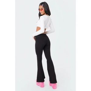 Close-up of stylish black low-waist flared pants and high-platform pink furry boots