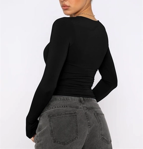 Close-up of slim-fit black long sleeve top with charcoal grey washed denim jeans back detail