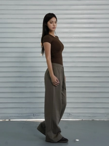 Detail of dark brown slim fit short sleeve T-shirt paired with grey wide-leg pants