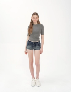 Detail of slim fit grey crew neck t-shirt with rolled hem denim shorts and white sneakers