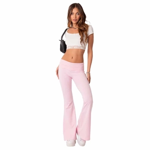 Pink low-rise flared yoga pants with white lace crop top on a female model