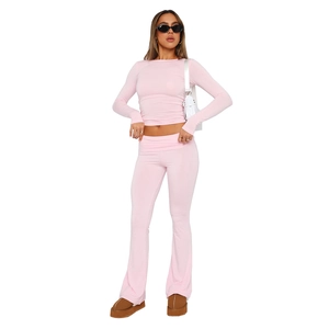 Detail view of pink slim-fit long-sleeve crop top and high-waist flared yoga pants set